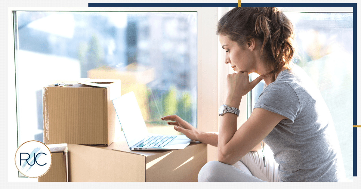 women on computer with moving boxes