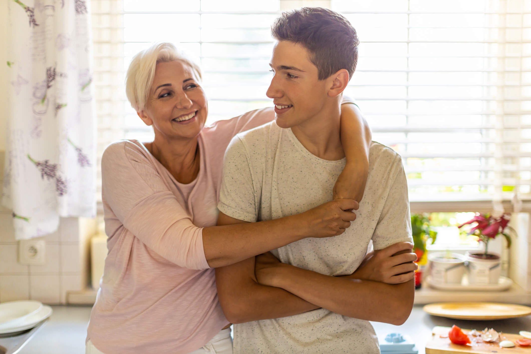 Mother hugging teenage son